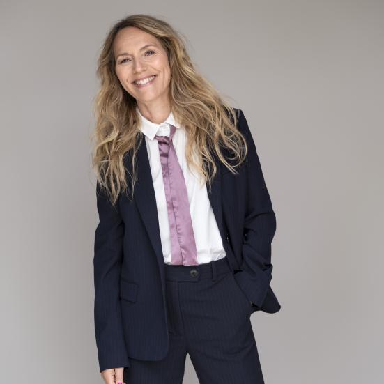 Alberte Winding iklædt et jakkesæt smiler til kameraet